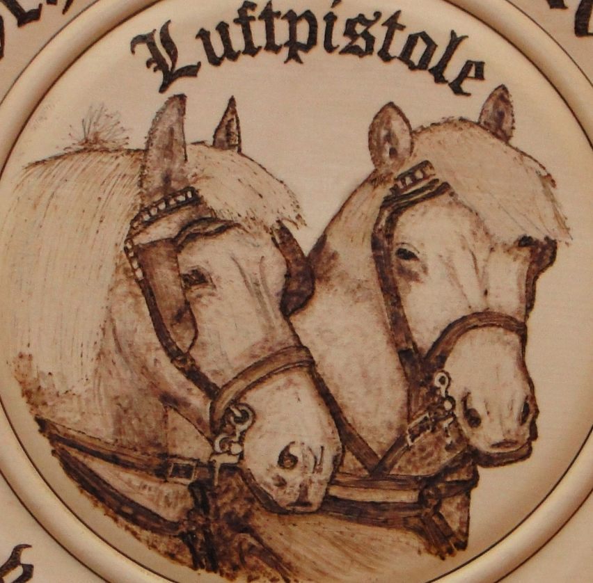 Die Brandmalerei präsentiert: die Köpfe von zwei majestätischen Pferden.