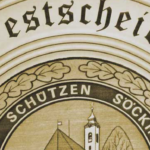 Festscheibe 2026 der Stefanischützen Söcking zum 125-jährigen Jubiläum – kunstvolle Schützenscheibe aus Ahorn mit Vereinswappen, Kirche, Zielscheibe und Eichenlaubkranz.