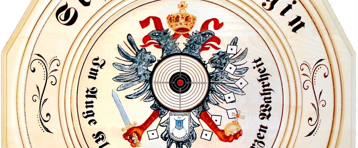 Die 12-eckige Schützenscheibe aus Ahornholz, handgedrechselt, lackiert, mit detailliertem Schützenvogel-Motiv und Zielscheibe in Acryl.